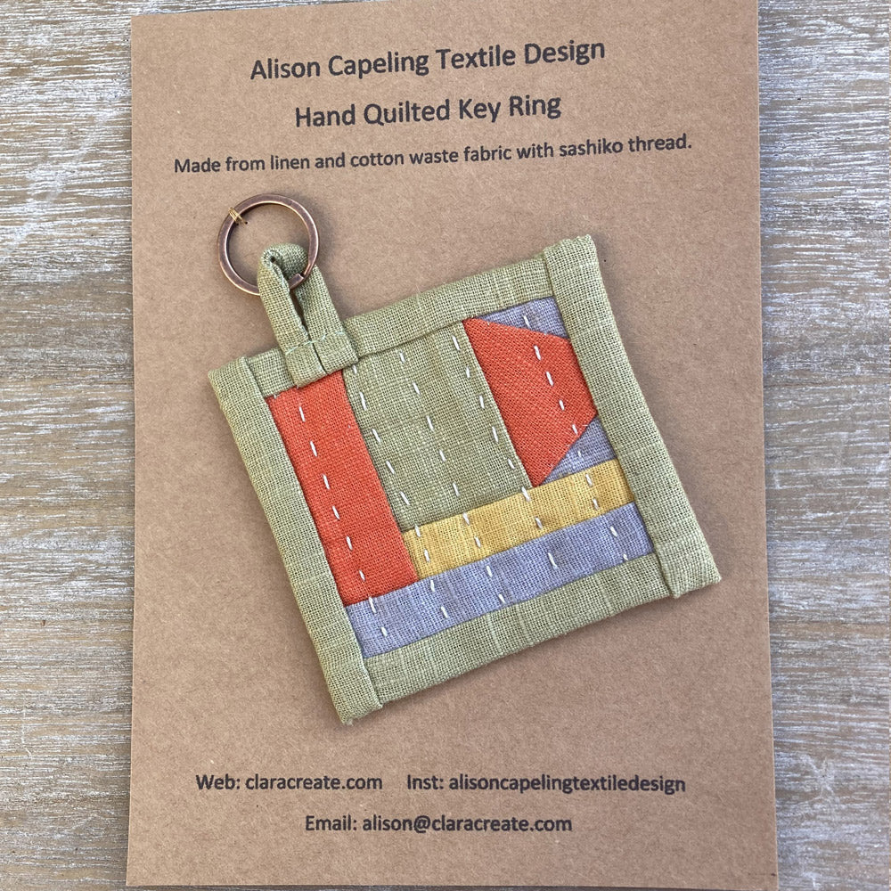 Hand quilted linen key fob stitch in sushiko thread. Green, gold, oranage and grey.