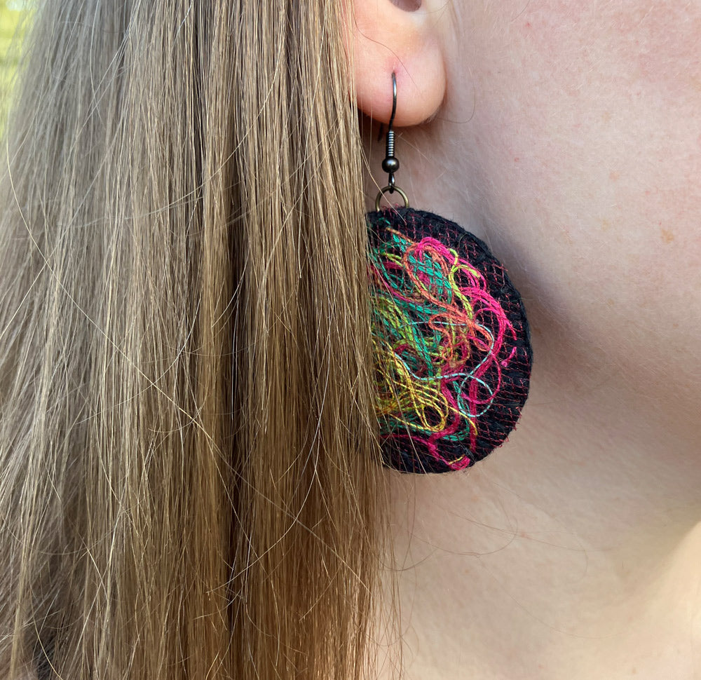 Handstitched natural black felt, drop earrings with a multi colour threads and antique copper ear wires.