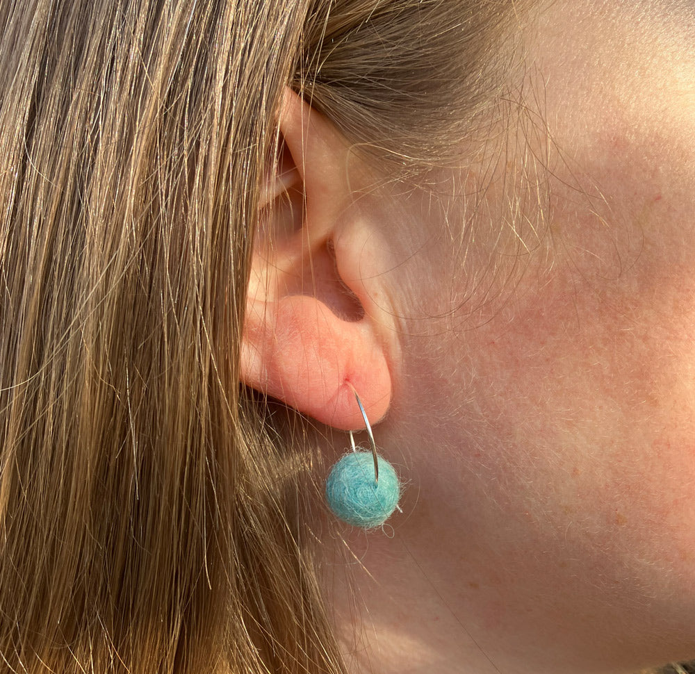 Ice Blue pom pom wool earrings with silver plated hoops.