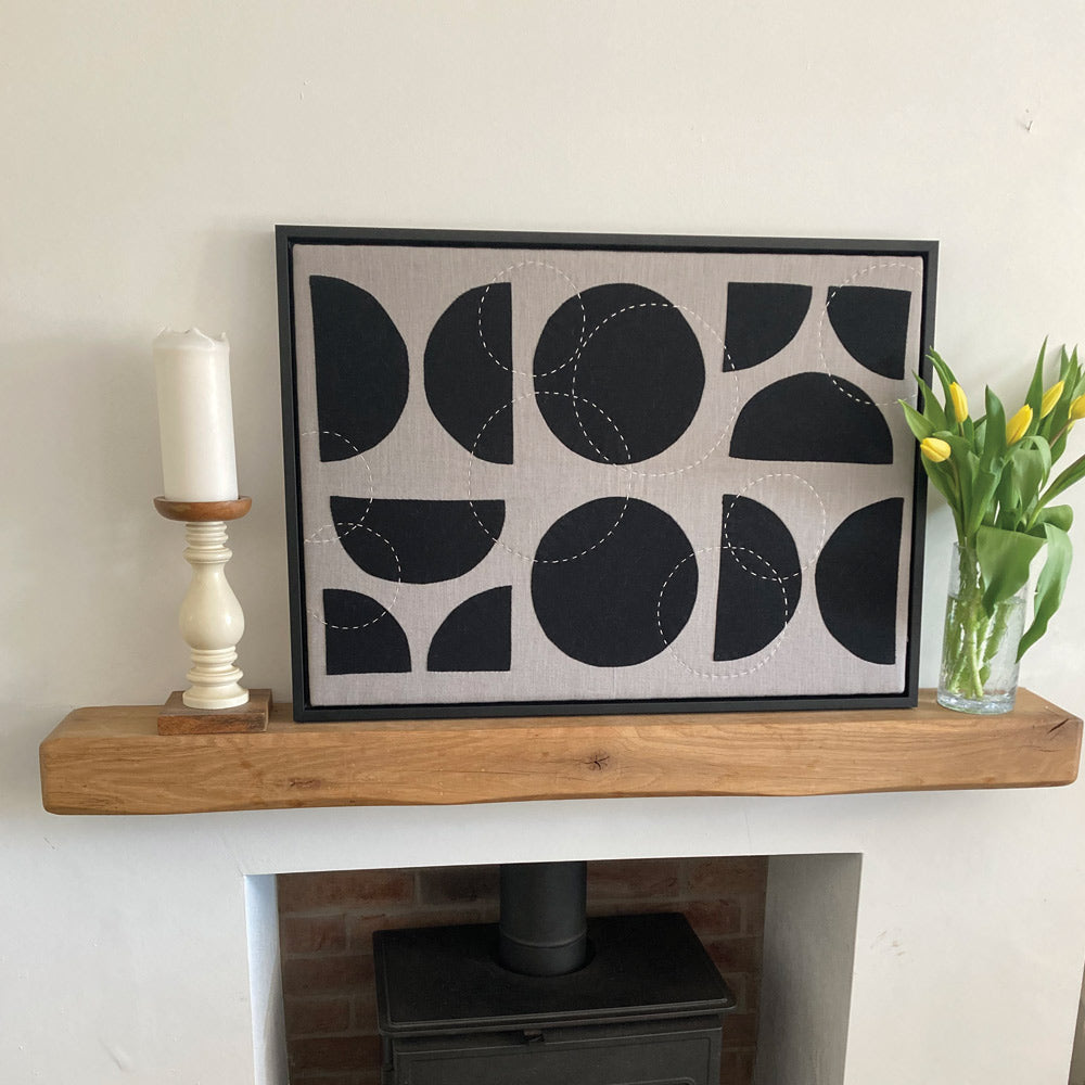 Large hand stitched mono fabric picture. Framed in a black wood. Hand sewn.
